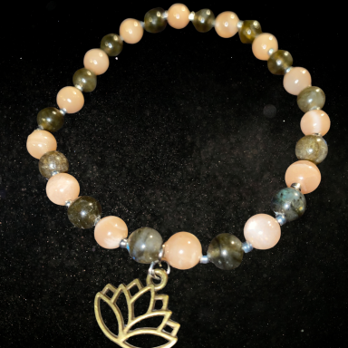 MYSTERE CELESTE Bracelet en perles avec pendant en forme de lotus. Perles variées de teintes douces.
